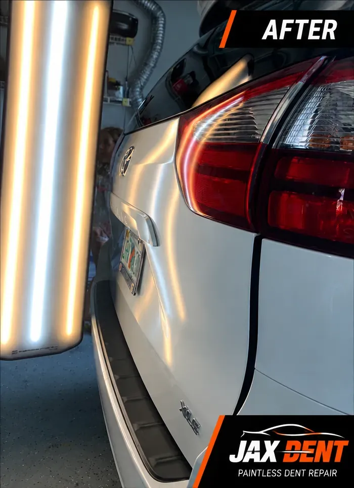 Rear liftgate of the white minivan after paintless dent repair, panel smooth
