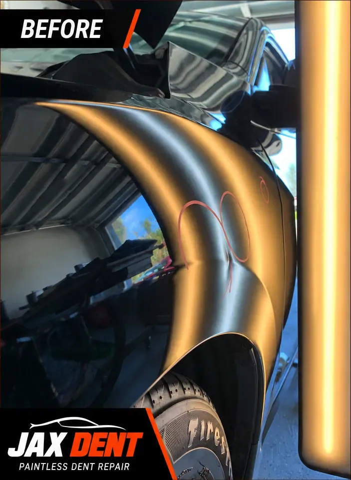 Several dents circled on the rear quarter panel of a black vehicle, before repair